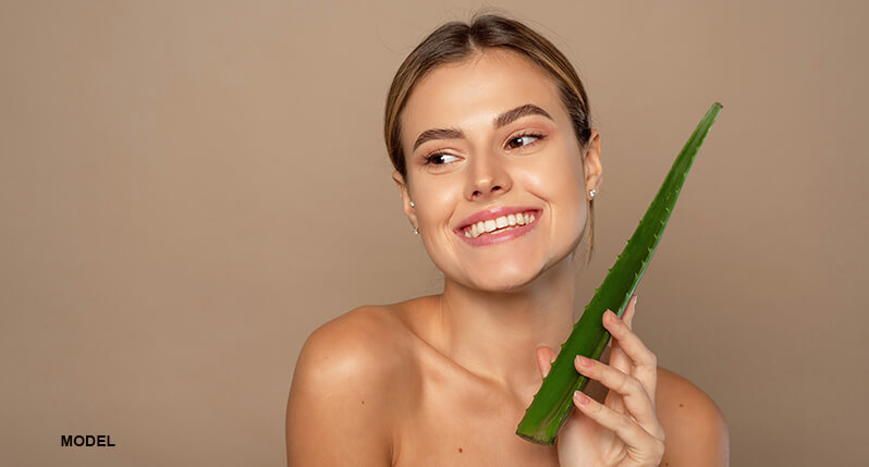 woman model with moisturized skin holding aloe